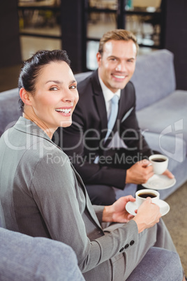 Businessman and businesswoman having tea during breaktime