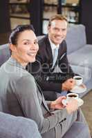 Businessman and businesswoman having tea during breaktime