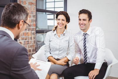 Smiling colleagues discussing with business professional