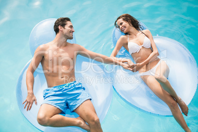 Happy young couple relaxing on inflatable ring
