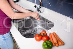 Woman washing hands at kitchen sink