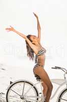 Brunette going on a bike ride on the beach