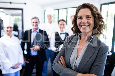 Happy female manager standing with arms crossed