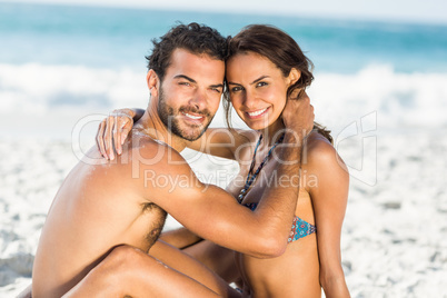 Cute couple hugging sitting on the beach