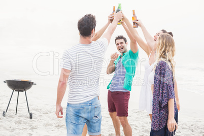 Group of friends toasting beer bottles on the beach