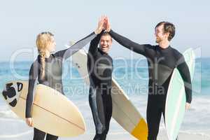 Happy surfer giving high-five to each other on the beach