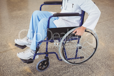 Midsection of doctor sitting on wheelchair