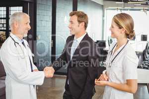Two confident doctors shaking hands with each other