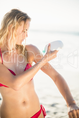 Woman applying sunscreen lotion on the beach