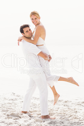 Man lifting woman on the beach