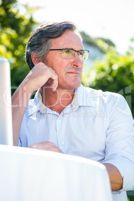 Casual businessman using laptop daydreaming