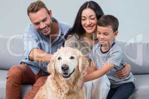 Parents and son petting dog
