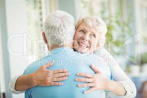 Happy senior woman hugging her husband