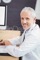 Happy doctor sitting on conference room