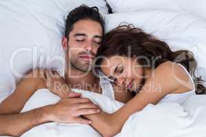 Close-up of couple sleeping on bed
