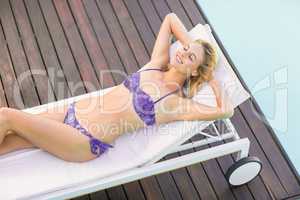 Beautiful young woman relaxing on sun lounger