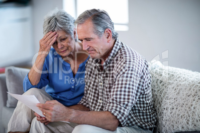 Worried senior couple checking the bills