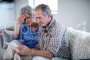 Worried senior couple checking the bills