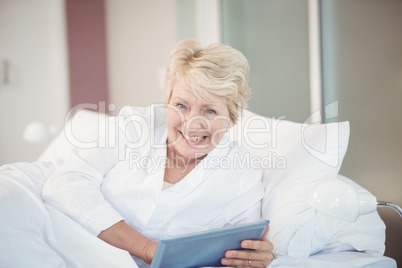 Portrait of happy senior woman using digital tablet