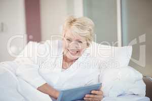 Portrait of happy senior woman using digital tablet