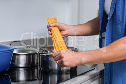 Close-up of man cooking spaghetti