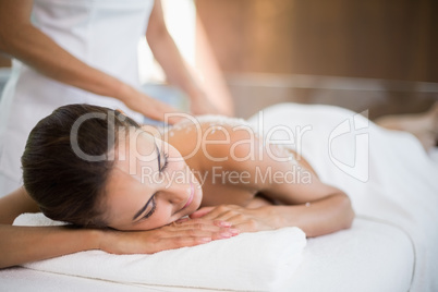 Woman receiving spa treatment from female masseur