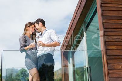 Happy couple with champagne at balcony