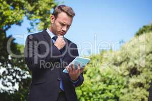 Serious businessman using tablet