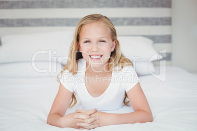 Portrait of smiling girl relaxing on bed