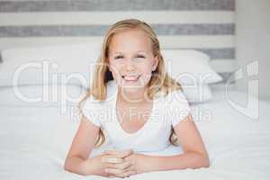 Portrait of smiling girl relaxing on bed