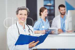 Portrait of happy female doctor holding medical reports