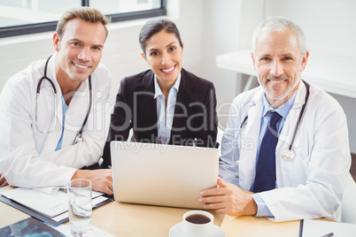 Portrait of medical team with laptop in conference room