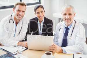Portrait of medical team with laptop in conference room
