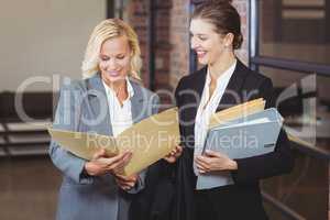 Happy businesswomen holding documents