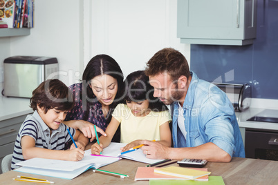 Parents helping children in doing homework
