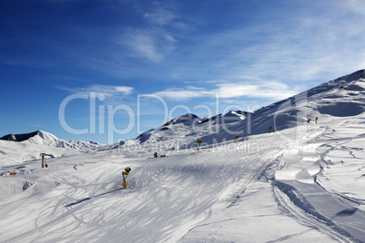 Ski slope with snowmaking at sun morning
