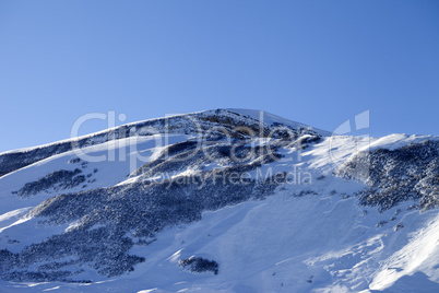Snowy mountains with track from avalanche after snowfall