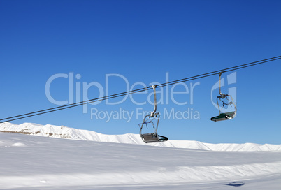 Chair-lift and blue clear sky at sun day