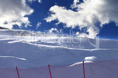 Off-piste slope during a blizzard and sunlight blue sky