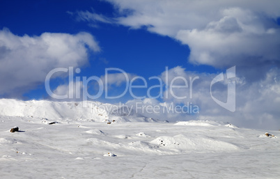 Ice-covered slope and snowy mountains in fog