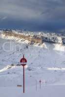Ski slope at evening and storm sky