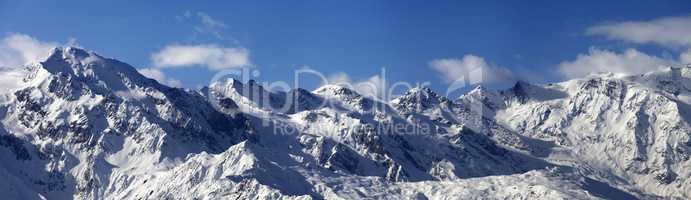 Panoramic view on snowy mountains in sunny day