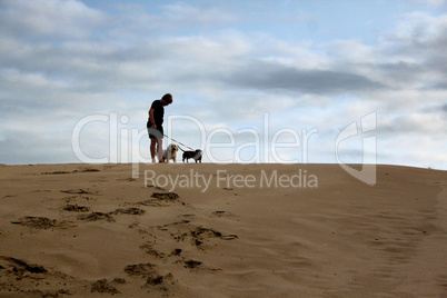Boy Standing with Dogs On Dune