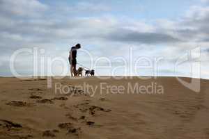 Boy Standing with Dogs On Dune