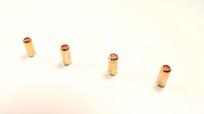 Pepper gas-cartridges and semi-automatic handgun, beauty-shot close-up macro-shot.
