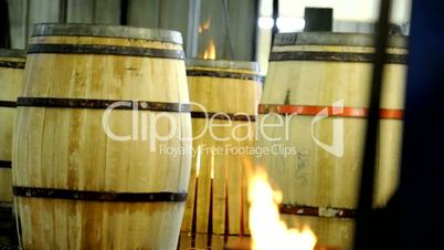 Flames rising from wood barrel during the wine barrel production. Vapours rising.