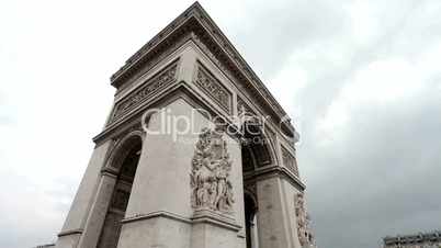 Arc De Triomphe on a cloudy day. Medium shot, corner. Tilt from the ground to the Arc.