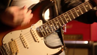 Guitarist. Close-up on a male hand playing hard on a electric guitar and then stop