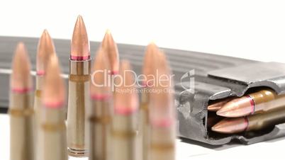 AK-47 ammunition. Defocus from a lying full magazine in the back to a bunch of upright bullets in the front.