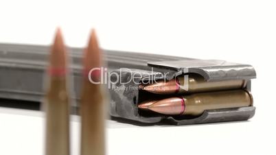 AK-47 ammunition. Defocus from a lying full magazine in the back to two upright bullets in the front.